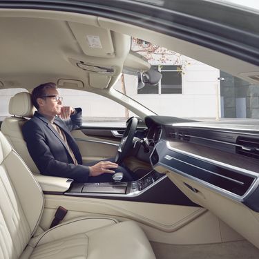 A mans sitting in the cockpit of the Audi A6 Sedan